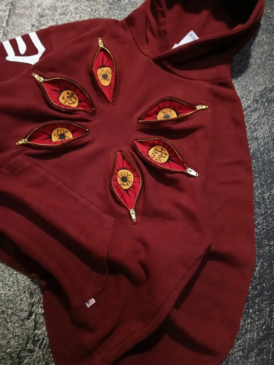 Vista lateral de cerca de una sudadera roja con capucha inspirada en Kokushibo de Demon Slayer, con seis ojos para hombre, hoodie gótica oversized anime streetwear Harajuku