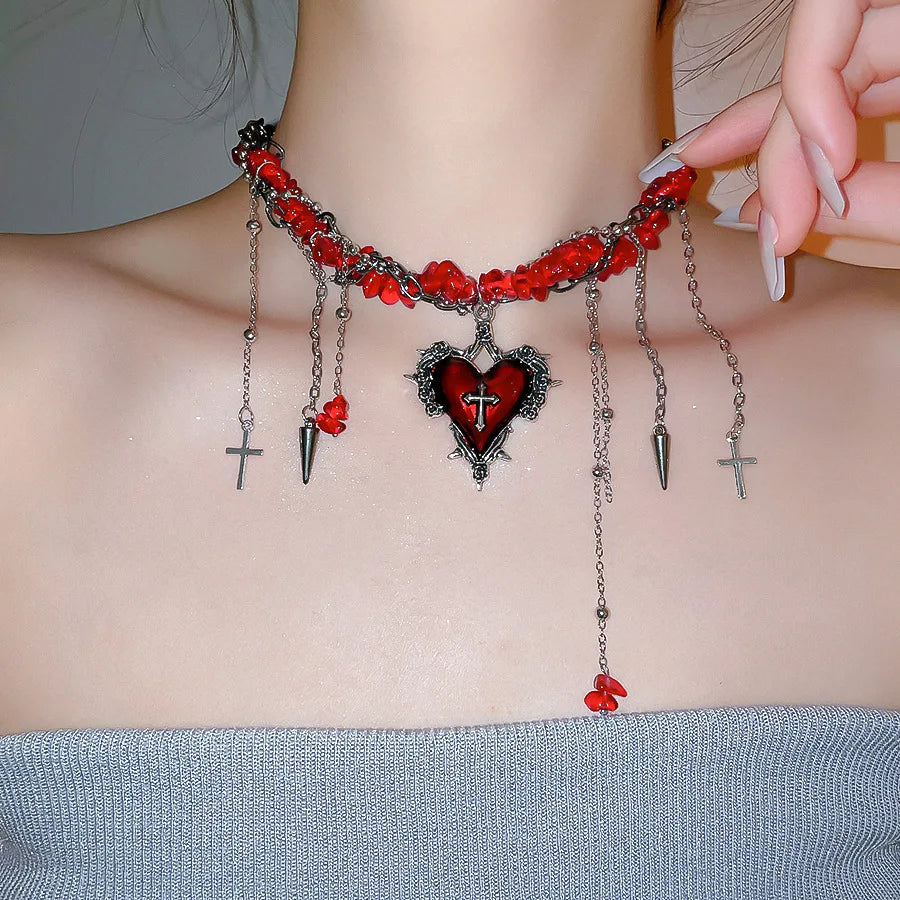 Colgante gótico de corazón con cruces, cadenas y pedrería, disponible en negro y rojo, esta imagen muestra el rojo vestido por una chica. Joyería romántica dark
