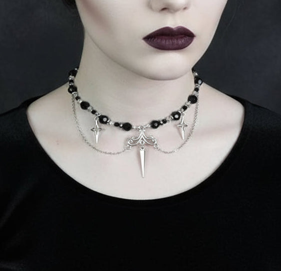 Una mujer vistiendo un Collar gótico de acero inoxidable, bolas de cuentas y estrellas plateadas en forma de cruz, acabado negro y plateado, 35+5cm
