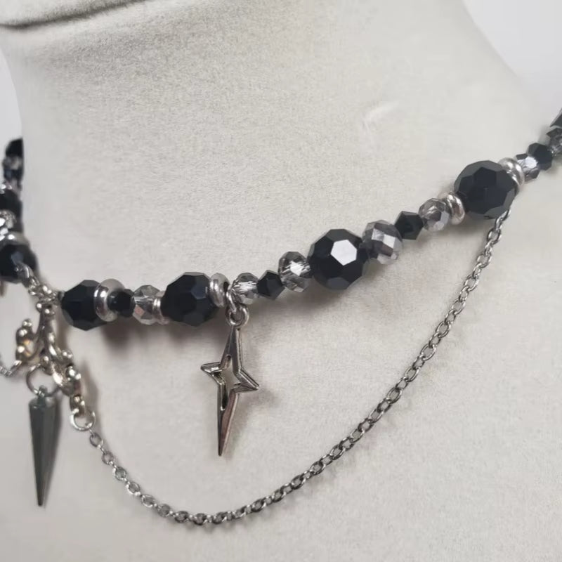 Imagen lateral de cerca de un Collar gótico de acero inoxidable, bolas de cuentas y estrellas plateadas en forma de cruz, acabado negro y plateado, 35+5cm
