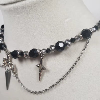 Imagen lateral de cerca de un Collar gótico de acero inoxidable, bolas de cuentas y estrellas plateadas en forma de cruz, acabado negro y plateado, 35+5cm

