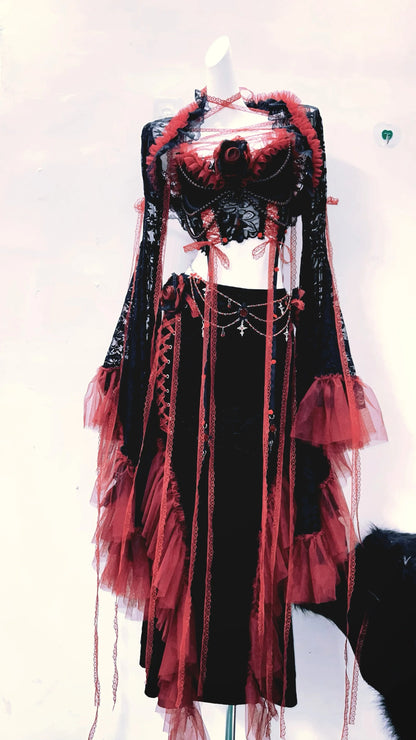 conjuto vestido completo separado, con top corto, mangas largas y falda larga, de colores rojo y negro con tiras rojas de tela