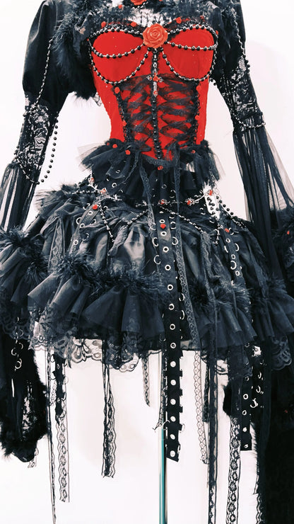 Falda corta negra de un vestido gotico, negro y rojo, con detalles metalicos. 