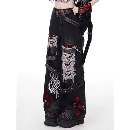 Esta imagen muestra una modelo a la que no se le ve el torso vistiendo unos pantalones vaqueros holgados para mujer góticos con rotos, tiras decorativas y parches rojos, son unos jeans retro punk alternativo, con una posición lateral.