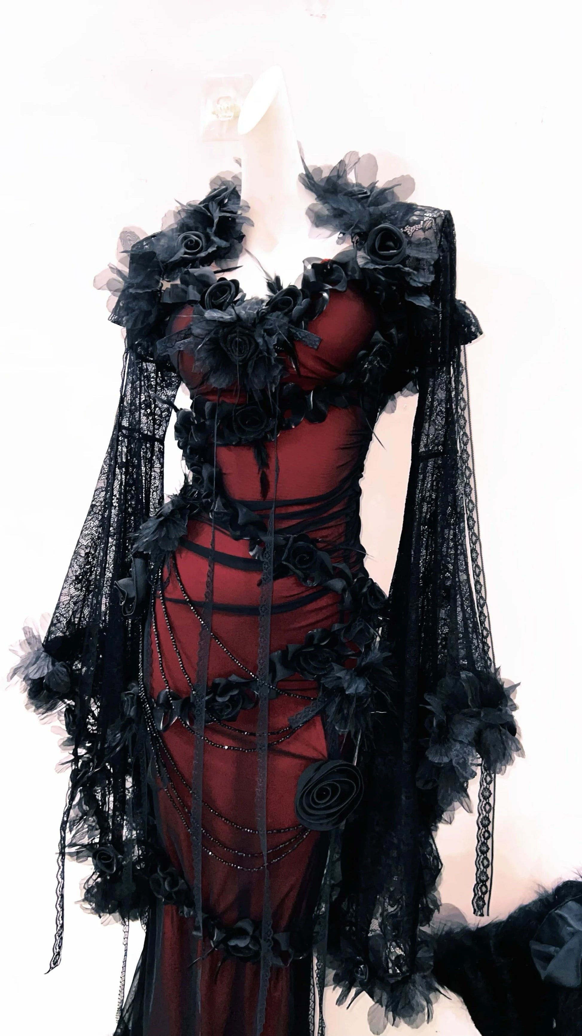 Imagen del lateral derecho de un vestido rojo burdeos y negro, con encaje en las mangas largas, gotico