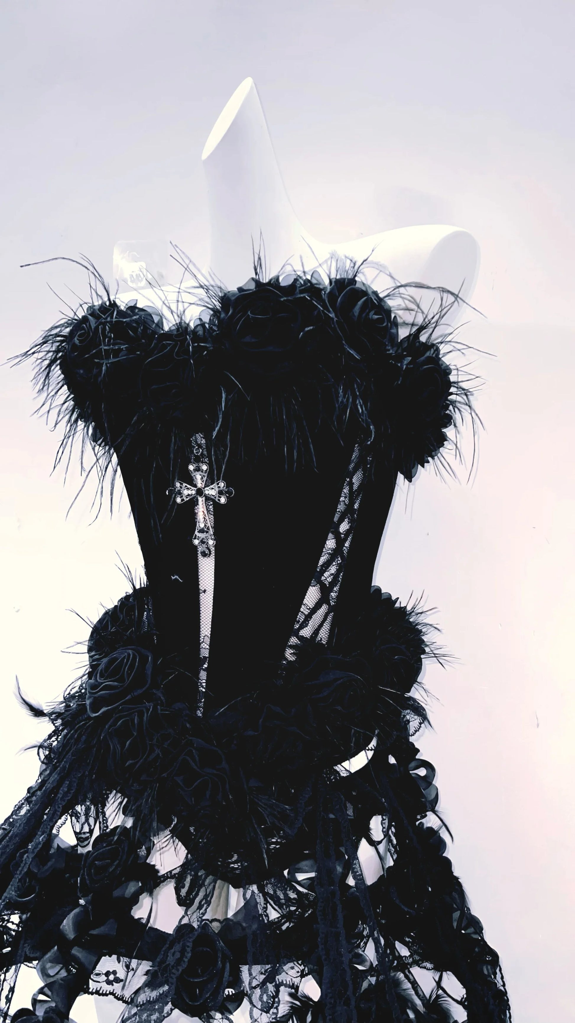 Imagen del lado derecho de el vestido gotico negro con pelaje y cruz, parte superior