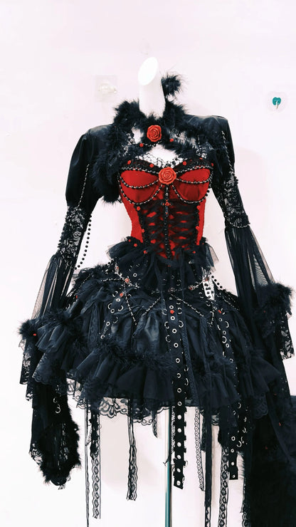 Vestido Gotico de color rojo y negro, con una falda y mangas largas. Tiene pelaje decorativo y detalles metalicos